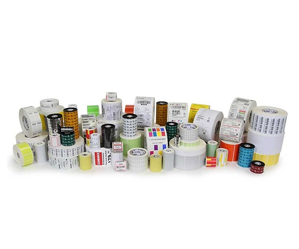 An assortment of printer supplies by Zebra which includes RFID labels, barcode labels and tags, and receipt paper.