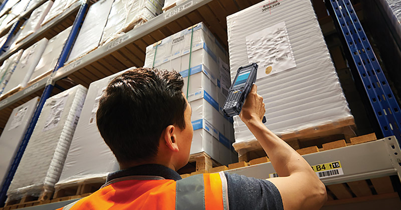 A man in a warehouse scanning a label with the Zebra MC9300 mobile computer.